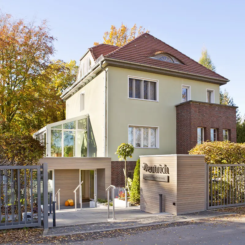 Freistehendes Praxishaus am Ende der Zufahrt mit neuem, barrierefreiem Eingangsbereich.